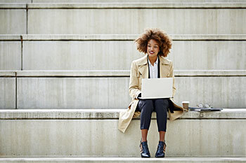 Junge Frau bewirbt sich am Laptop fuer das Fernstudium Steuerberater