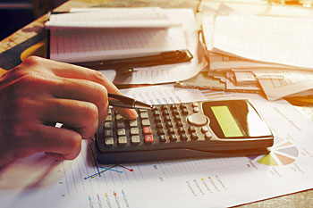 Student der Steuerlehre tippt in den Taschenrechner