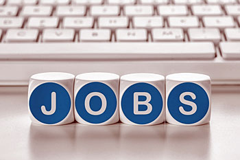 Vier kleine Wuerfel liegen vor einer Tastatur und haben die Aufschrift Jobs